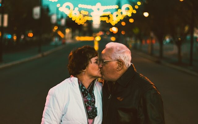 Old man and woman kissing each other. Love in longevity.