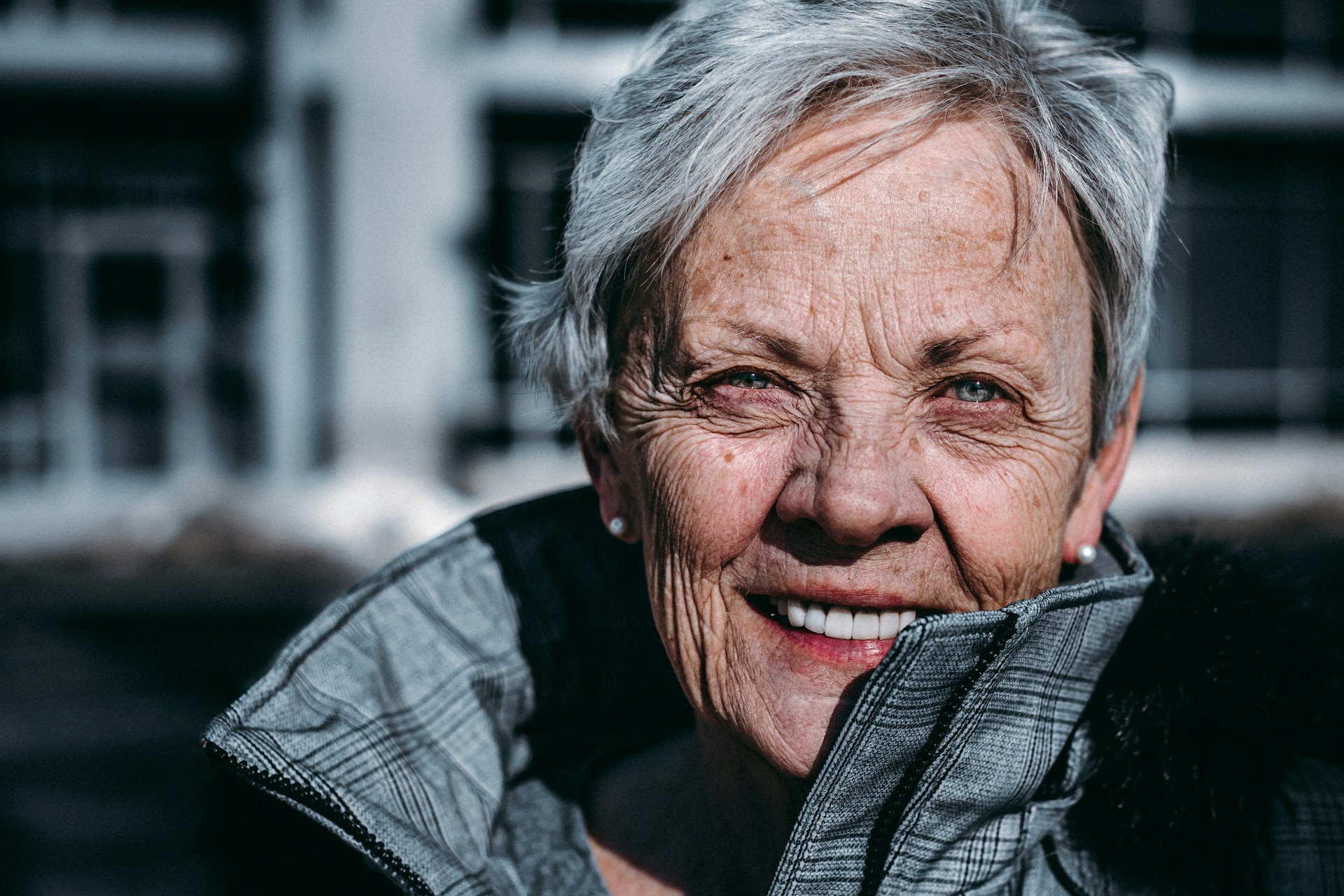 A smiling woman enjoying a moment outdoors, embodying the concept of 'vitality life' with her vibrant and energetic expression.